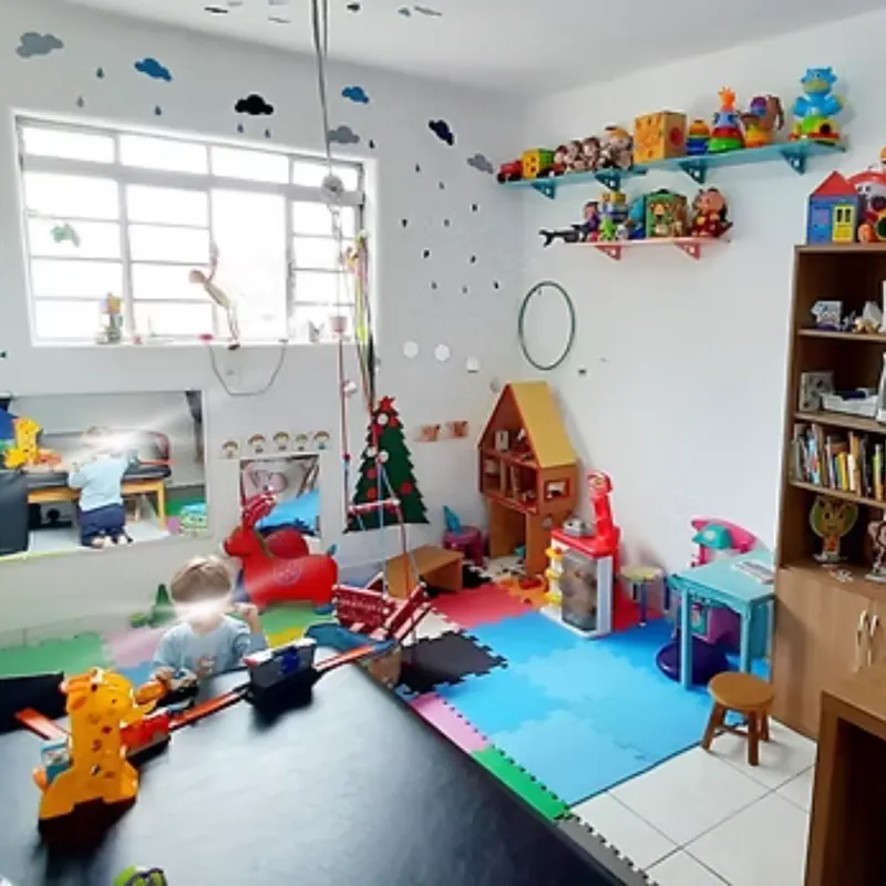 Sala lúdica com brinquedos pedagógicos e tapete colorido