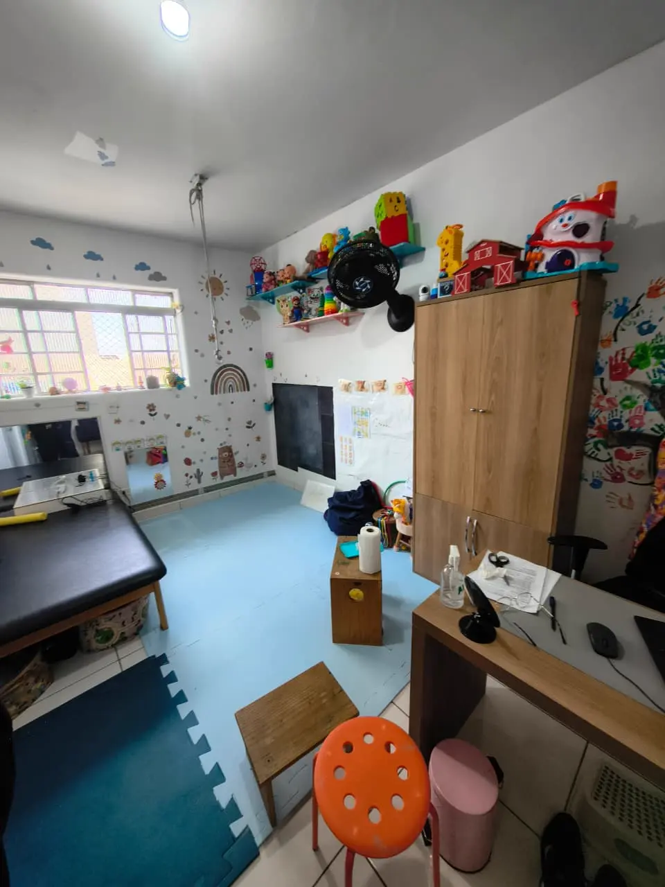 Espaço de atendimento com lousa e brinquedos pedagógicos
